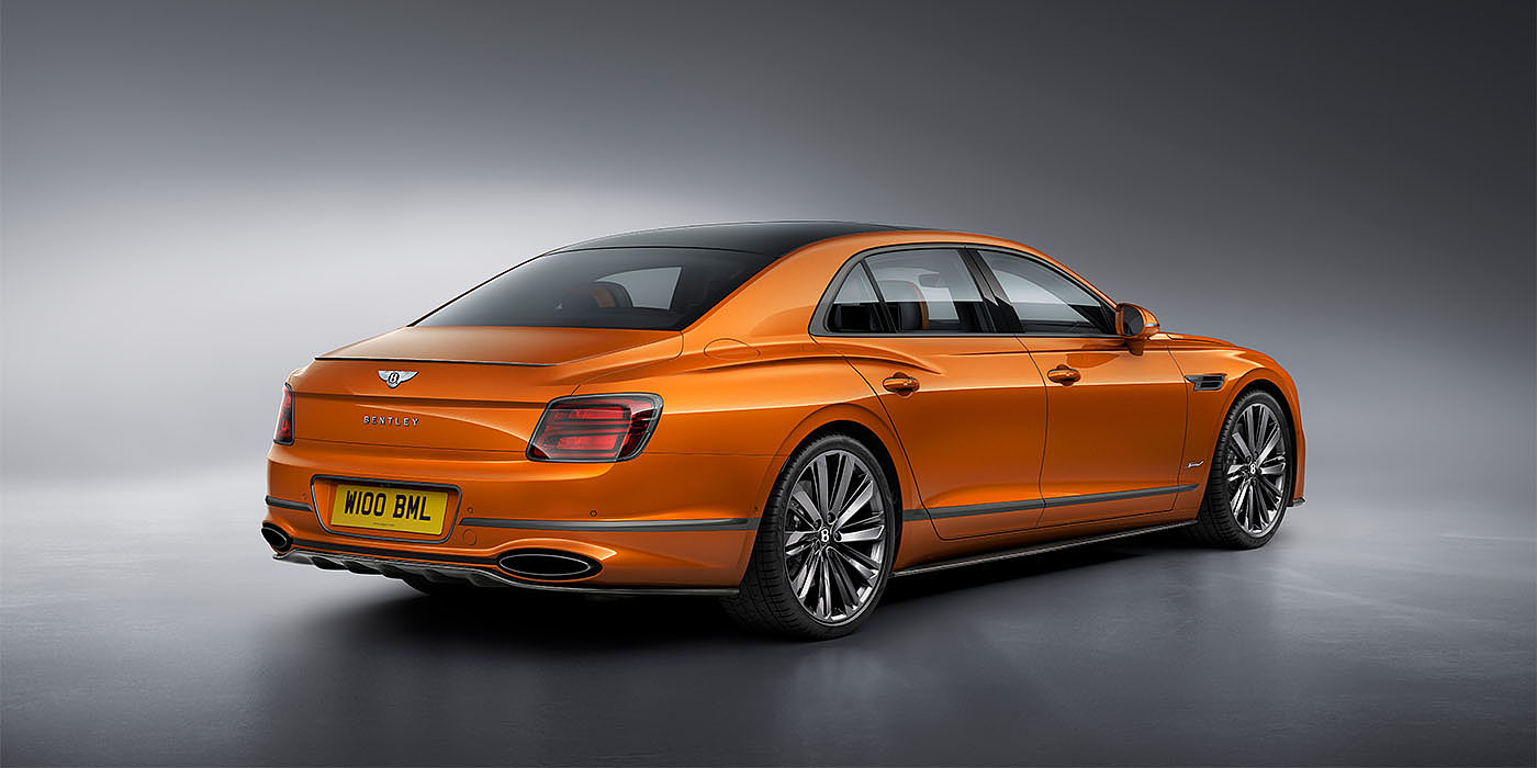 Bentley Emirates -  Dubai Bentley Flying Spur Speed in Orange Flame colour rear view, featuring Bentley insignia and enhanced exhaust muffler.