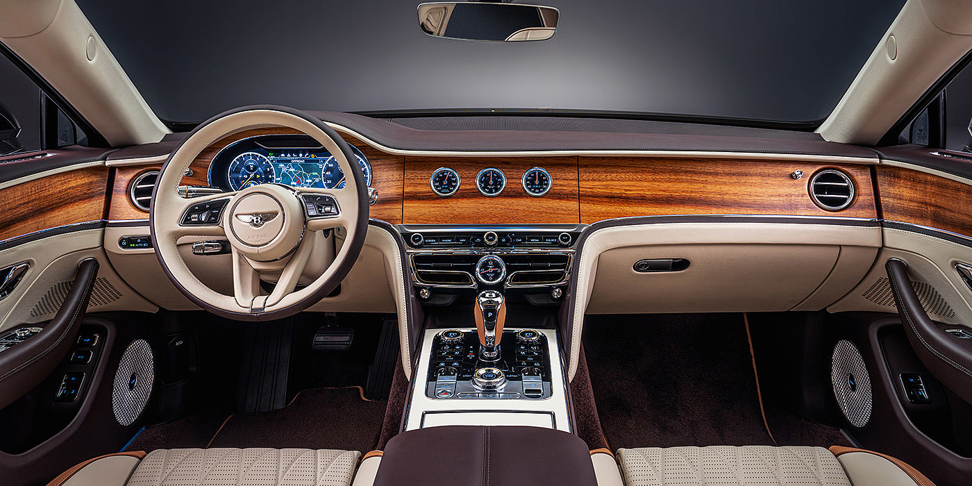 Bentley Emirates -  Dubai Bentley Flying Spur Odyssean sedan front interior in Open Pore Koa veneer with Piano Linen console and Linen and Burnt Oak hides