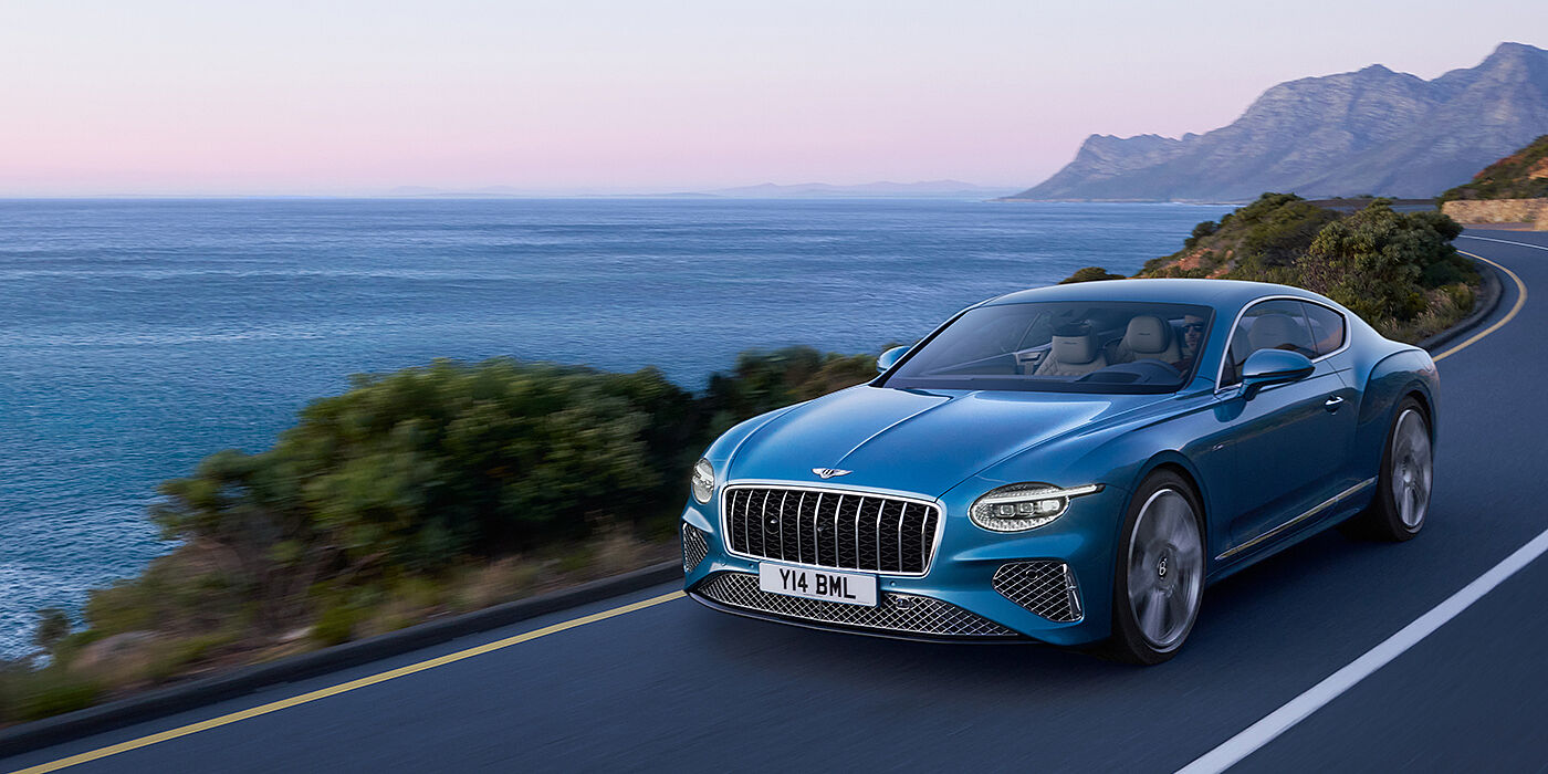 Bentley Dubai New Bentley Continental GT Azure coupe in Light Windsor blue paint with 22 inch Azure wheels and chrome grill, driving dynamically by the se