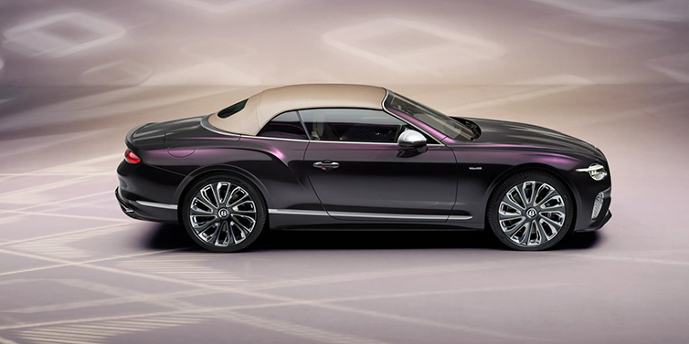 Bentley Dubai Bentley Continental GTC Mulliner convertible in profile with hood up, in Tanzanite Purple paint and 22 inch Mulliner painted and polished wheels