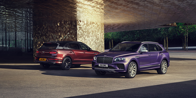 Bentley Dubai A duo of Bentley Bentayga Extended Wheelbase Mulliner SUVs parked in a city environment, with Tanzanite Purple and Cricket Ball red exterior paint