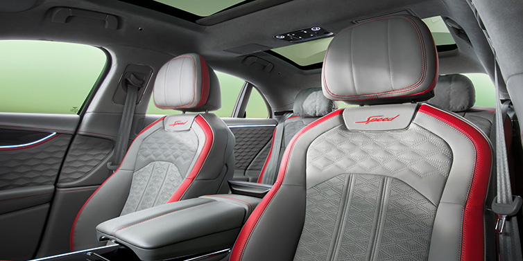 Bentley Dubai Bentley Flying Spur Speed sedan interior showing front and rear seats in Hotspur red and Gravity Grey hides, with Speed seat emblems