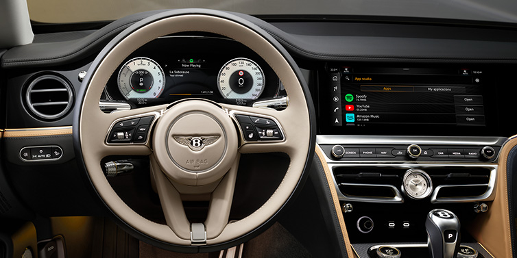 Bentley Dubai Bentley Flying Spur Mulliner sedan front interior detail of steering wheel and driver screens surrounded by Linen and Beluga black hides