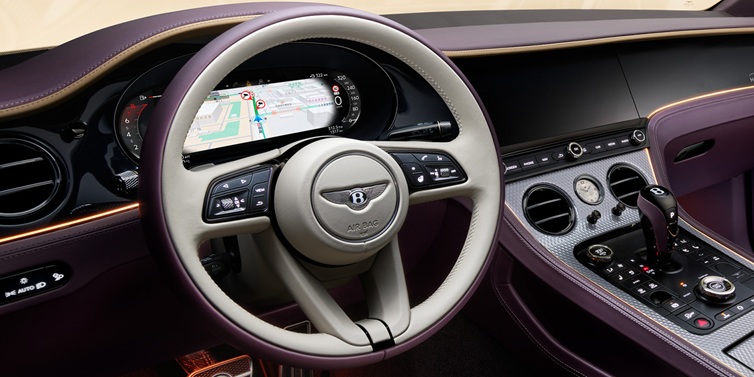 Bentley Dubai Bentley Continental GT Mulliner coupe front interior showing steering wheel and drivers screens surrounded by Linen and Damson hides and Grand Black veneer