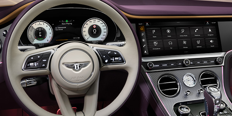 Bentley Dubai Bentley Continental GTC Mulliner convertible steering wheel and drivers screens surrounded by Damson purple and Linen hides